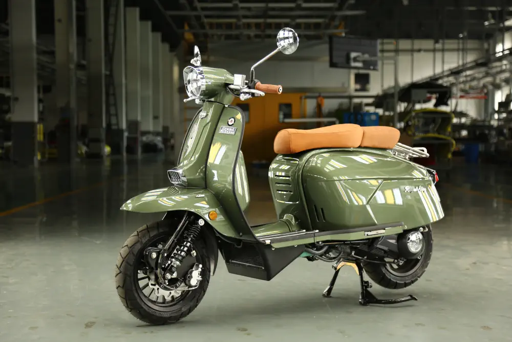 Ein olivgrüner Royal Alloy Retro-Roller mit brauner Sitzbank steht in einer großen Halle auf einem hellen Boden.